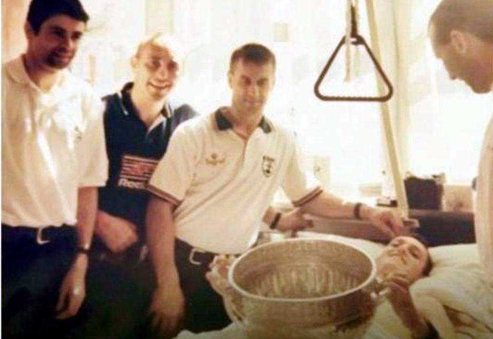 Lester in his hospital bed in 1998, with visitors gathered around him